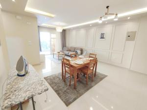 a living room with a table and chairs and a couch at white Bear in Madinaty +19 photos