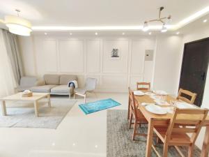 a living room with a table and a couch at white Bear in Madinaty