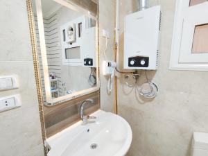 a bathroom with a sink and a mirror at white Bear in Madinaty