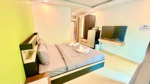 a small bedroom with a bed and a television at Abdullah Residence in Patong Beach