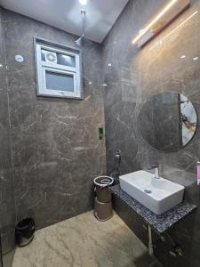 a bathroom with a sink and a mirror at Hotel The King Palace in New Delhi