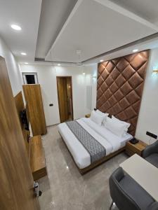 a bedroom with a bed and a desk and a chair at Hotel The King Palace in New Delhi