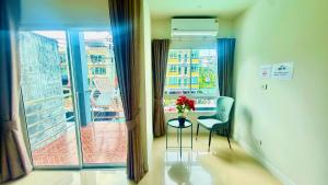 a room with a window and a table with a vase of flowers at Abdullah Residence in Patong Beach