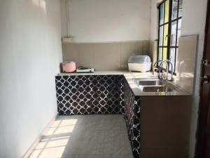 een keuken met een spoelbak en een aanrechtblad bij Asyun Homestay 1 Double Storey House Sg Buloh Town in Sungai Buluh