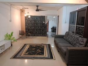 a living room with a couch and a rug at Asyun Homestay 1 in Sungai Buluh +2 photos