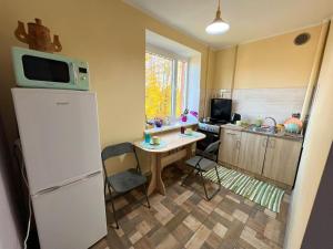 a kitchen with a refrigerator and a table with a microwave at Sigulda's Laimas Apartment Self-Check in in Sigulda