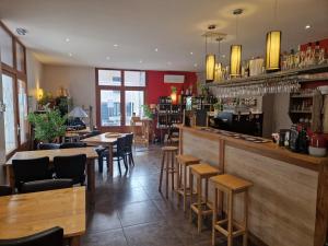 a restaurant with a bar with wooden tables and chairs at Hôtel Bistrot Les Tanins in Saint-Antoine