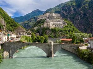 a bridge over a river with a castle at B&B Vecchio Torchio di Bard in Bard