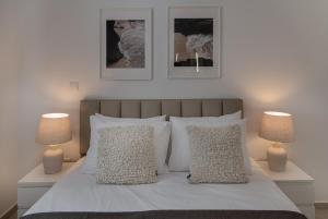 a bedroom with a white bed with two lamps at Avyra Residences Chrysakama Sea View in Polis Chrysochous
