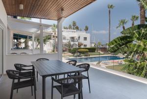 a patio with a table and chairs and a pool at Avyra Residences Chrysakama Sea View in Polis Chrysochous