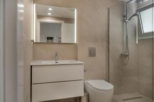 a bathroom with a sink and a toilet and a mirror at Avyra Residences Chrysakama Sea View in Polis Chrysochous +10 photos