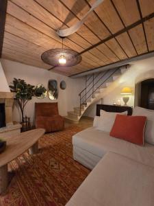 a living room with a couch and a staircase at Charming village house 10 min from Uzès in Saint-Victor-des-Oules