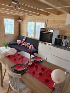 a kitchen and living room with a table with roses on it at Le Chalet de Françesca in Sérignan