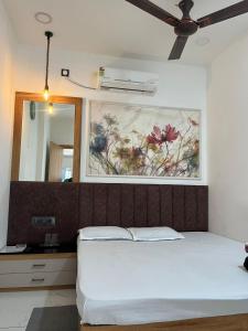 a bedroom with a bed and a painting on the wall at Mahaveer Lodge in Siliguri +8 photos