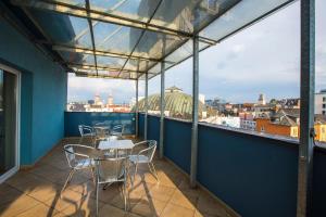 a balcony with tables and chairs and a view of the city at Hotel Trend in Pilsen