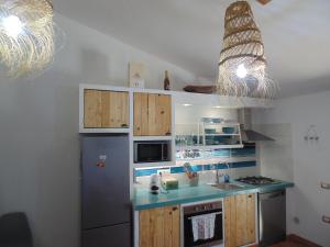 a kitchen with a refrigerator and a sink at Torre Comfort House in Torre delle Stelle +16 photos