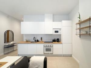 a kitchen with white cabinets and a couch at TAYP Navalmoral Estudios in Navalmoral de la Mata