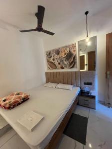 a bedroom with a bed and a ceiling fan at Mahaveer Lodge in Siliguri