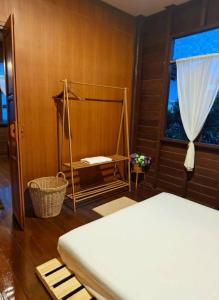 a bedroom with a bed and a window at BaanBaimai Homestay in Chiang Rai