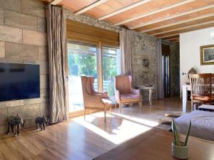 un soggiorno con TV su un muro di pietra di Can Cinto a Vilamacolum