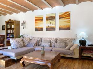 un soggiorno con divano e 3 dipinti alle pareti di Can Cinto a Vilamacolum