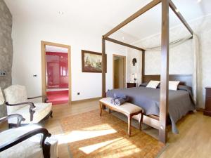 una camera con un grande letto a baldacchino e una sedia di Can Cinto a Vilamacolum Altre 30 foto