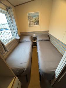 two beds in a small room with a window at Meadow Banks Combe Haven in Hastings +27 photos