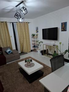 a living room with a couch and a tv at Saffron Homes in Eldoret