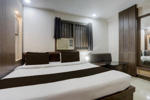 Un dormitorio con una cama blanca grande y una ventana en Collection O Bank More Dhanbad Formerly Hotel Sri Ganesh Ji, en Dhanbād