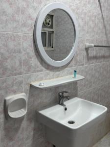 een badkamer met een wastafel en een spiegel bij هومي Homi in Salalah