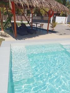 a swimming pool with a table and chairs in a resort at Dom's Oase in Bolod +39 photos