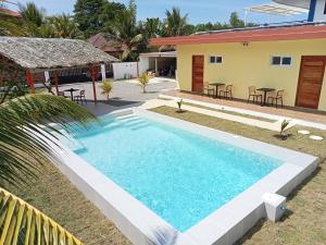 a swimming pool in front of a house at Dom's Oase in Bolod