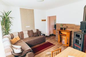 a living room with a couch and a wood stove at Bükkfői vendégház in Borzont