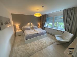 a bedroom with a bed and a chair and a window at Ferienwohnung Edelweiss am Steinberg in Goslar mit Terrasse und Garage in Goslar