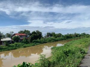 a dirt road next to a river with a house at De Suria Homestay Jitra- 3BR with 4 Aircons in Jitra
