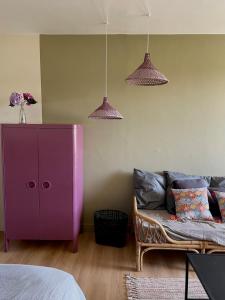 a purple cabinet and a couch in a bedroom at Studio Ker Boucan à 5 min de la plage in Saint-Paul +17 photos