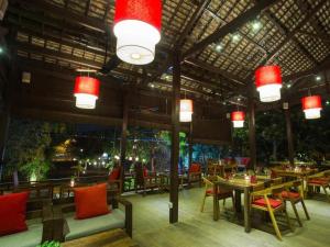 a restaurant with tables and chairs and red lights at La Fontaine de Tara in Siem Reap