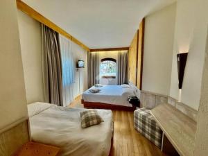 a hotel room with two beds and a window at Hotel Comtes De Challant in Fenis +15 photos