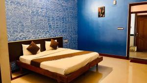 KālvādiAdvaitha Serenity Resorts的卧室里有一张床，墙壁是蓝色的