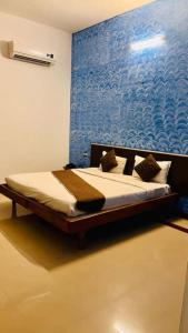 a bed in a room with a blue wall at Advaitha Serenity Resorts in Kālvādi