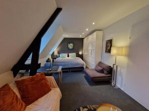 a bedroom with a bed and a couch in a room at Appartement historisch centrum Antwerpen in Antwerp