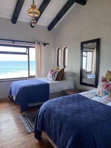 a bedroom with two beds and a view of the ocean at Vistas al Mar in Groot Brak Rivier