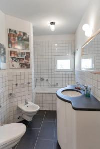 een badkamer met een wastafel, een toilet en een bad bij Chesa Saura in Ponte