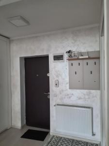 a hallway with a black door and a white wall at Fiald-Apartament Nou in Bacău