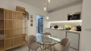 a kitchen and dining room with a glass table and chairs at Viana apartaments in Bilbao