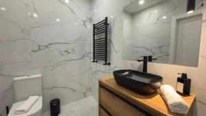 a bathroom with a black sink and a marble wall at Viana apartaments in Bilbao