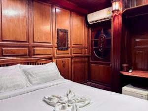 a bed in a room with wood paneled walls at Sukhum Ban Songthai in Bangkok