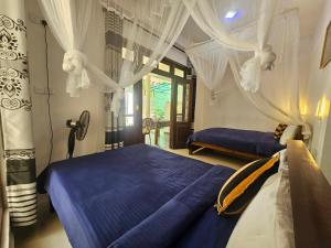 two beds in a room with white curtains at The Canapy Nest Ella in Ella