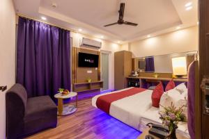 Una habitación de hotel con una cama y un televisor. en Hotel Angel Pink The Premium Rooms, en Ghaziabad
