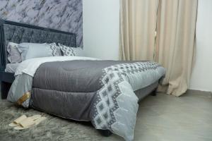 a bed with a gray blanket and a pair of shoes at Kari Cozy Homes in Nairobi +7 photos